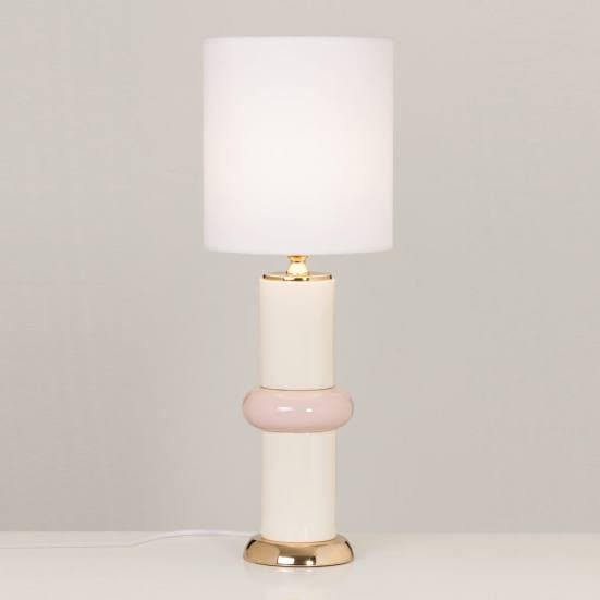Lámpara de mesa rosa y blanca de cerámica encendida