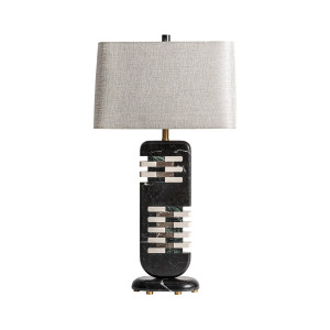 Lámpara de sobremesa Carla de estilo art deco, fabricado en mármol en color negro, combinado con metal en color dorado y poliéster en color arena con acabado jaspeado. Producto desmontable.
